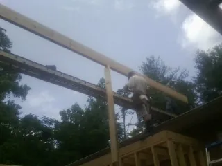 Carpenter setting a ridge beam over a new addition frame — Ice Dam Removal by Roofing Brothers in Baker City