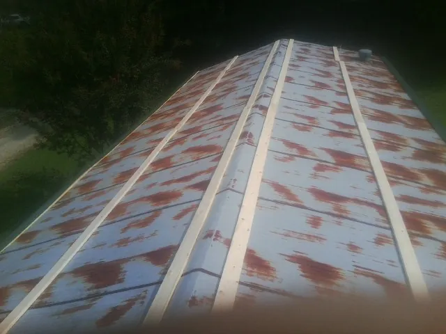 Rusted metal roof panels with new wood purlins before replacement — Storm Damage Roof Repair in Baker City by Roofing Brothers