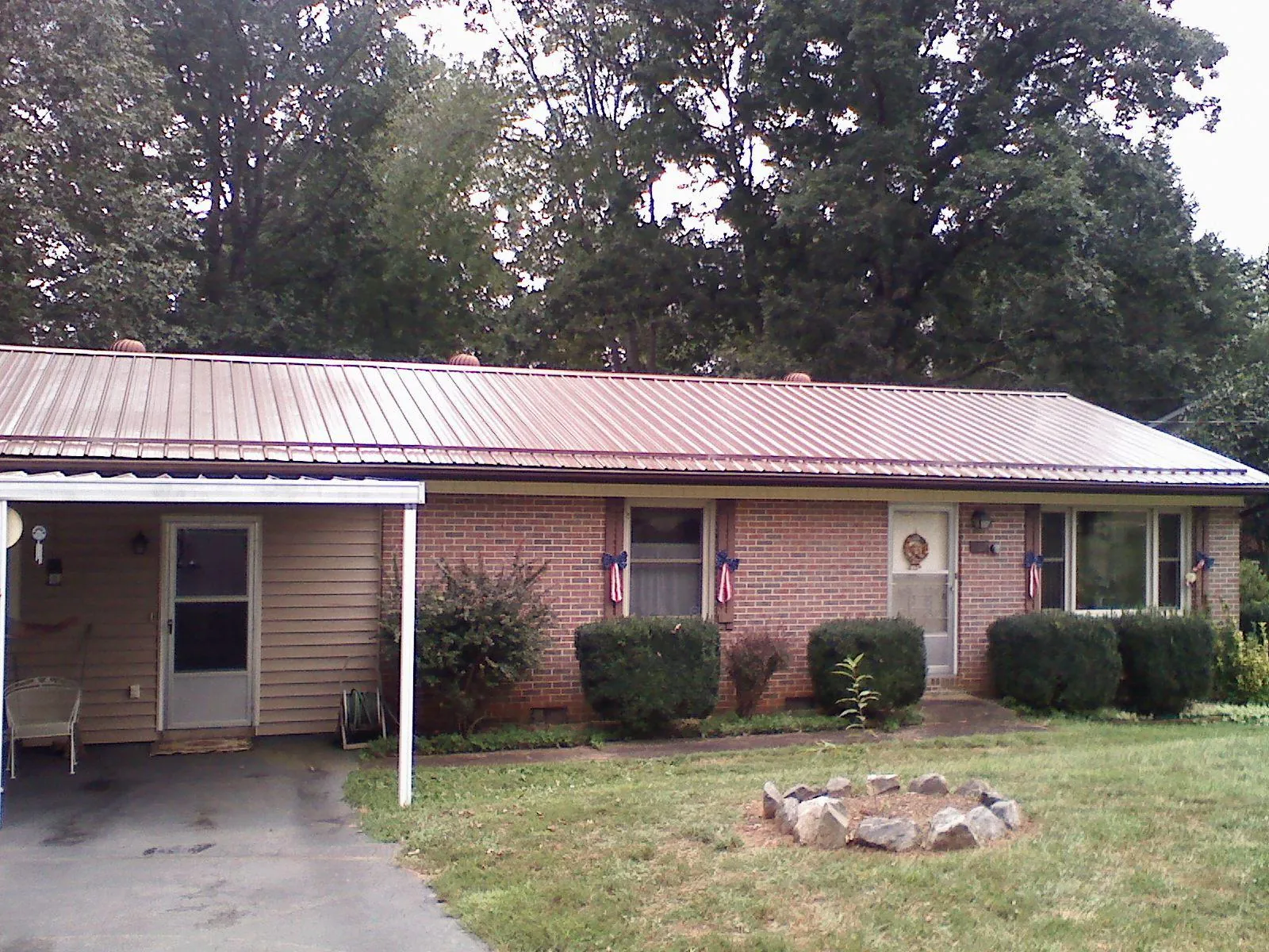 Bronze metal roof and carport on a brick ranch home — Roof Repair work by our crew in Baker City